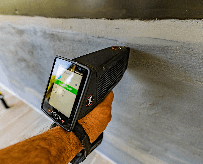 A handheld lead paint analyzer scanning a wall