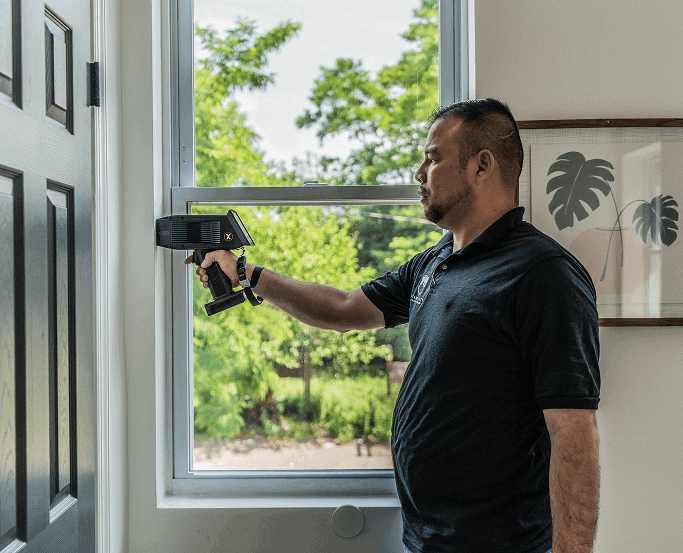 An inspector scanning a window with a lead paint analyzer