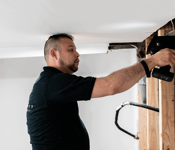 Professional home inspector examining wall structure for safety and integrity.